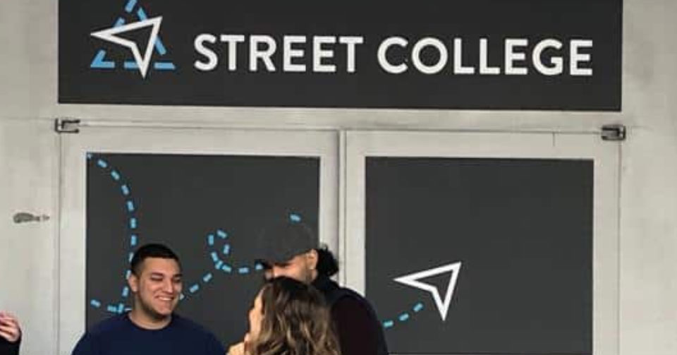 Menschen stehen vor dem Eingang des Street College